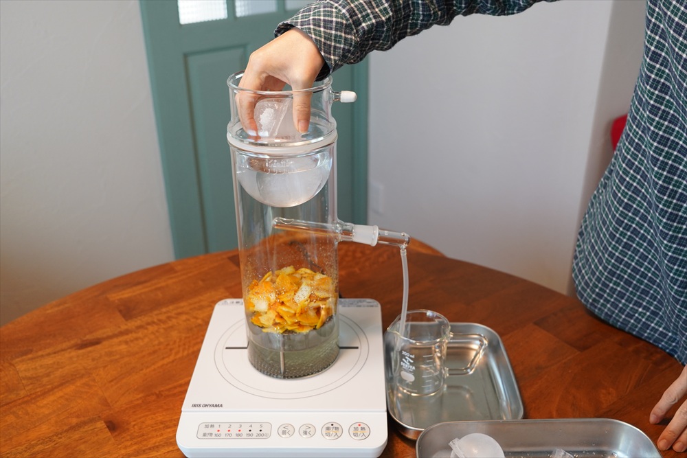 蒸留器の上部に氷を入れる様子